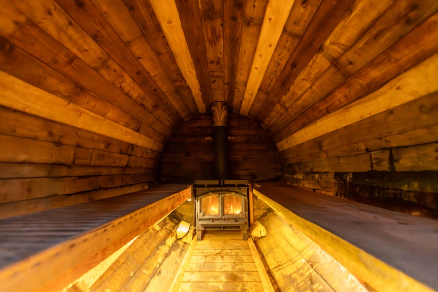 Inside the wood-fired barrel sauna with the stove lit