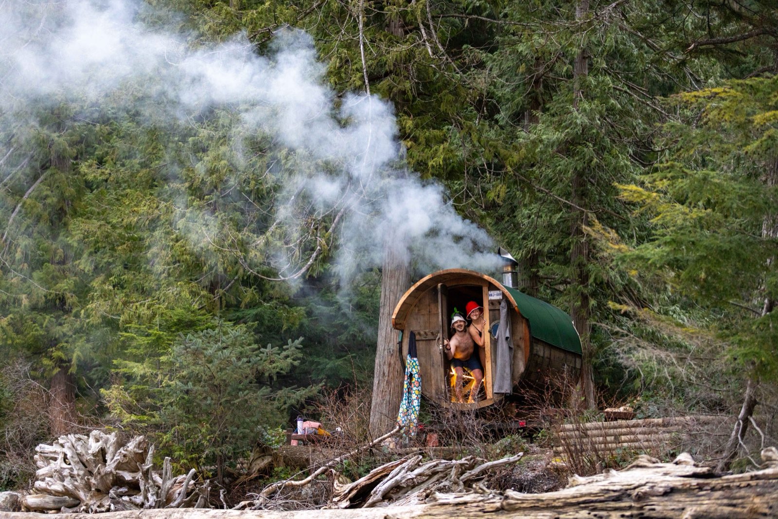 Steam rising off two people outside a wood-fired sauna